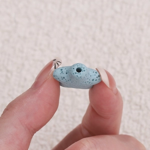 Makroaufnahme einer hellblauen sternförmigen Lavasteinperle mit natürlichen Poren für DIY