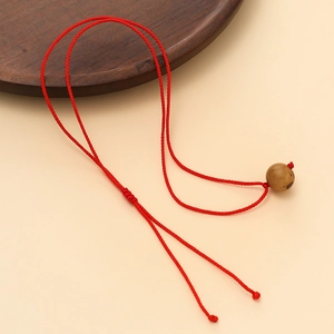 Détail d'un cordon de collier tressé rouge avec nœud réglable et perle en bois ronde