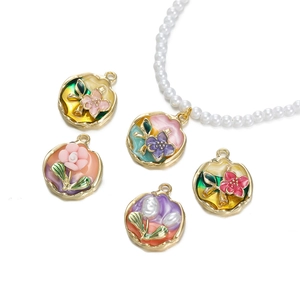 Vista detallada de colgantes de flores esmaltadas vintage con collar de perlas