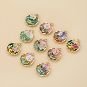 Detalle de colgantes de flores esmaltadas con perlas para la creación de joyas DIY