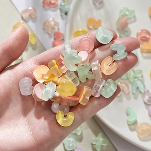 Close-up of colorful resin alphabet beads in hand for DIY jewelry and phone case crafts