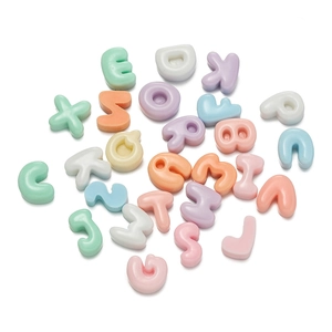 Flat lay of macaron-colored resin alphabet beads scattered on white background for DIY crafts