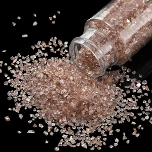 Macro shot of iridescent champagne glass crystals pouring from a bottle for DIY nail art