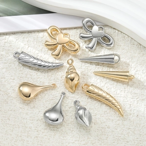 Detailansicht goldener und silberner Anhänger in Schleifen- und Hornform für DIY-Schmuck