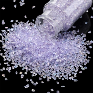 Macro shot of iridescent light purple glass gravel for DIY crafts on black background