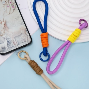 Dettaglio di cordini per telefono intrecciati colorati con clip metalliche su sfondo