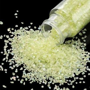 Close-up of light green iridescent glass gravel for DIY crafts and nail art decor
