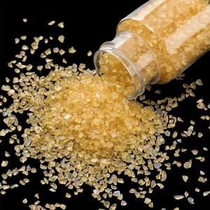 Detailed view of iridescent golden glass gravel pouring from a clear 30g bottle
