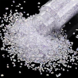 Macro shot of iridescent white glass shards spilling from a jar for nail art and DIY