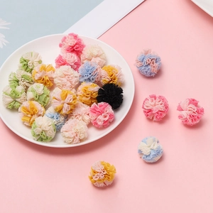 Detalle de bolas de encaje de 2,5 cm de colores para accesorios de pelo DIY en un plato