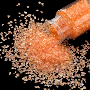 Macro shot of 30g iridescent orange glass gravel pouring for DIY nail art and resin crafts