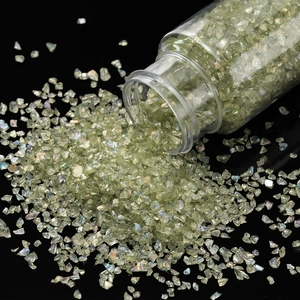 Macro shot of iridescent pale green glass crushed stones spilling for DIY nail art