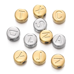 Gros plan de perles rondes de 7 mm en acier doré et argenté avec lettres pour bijoux DIY