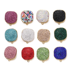 Macro view of square stainless steel pendants set with 12 multi-colored rhinestones