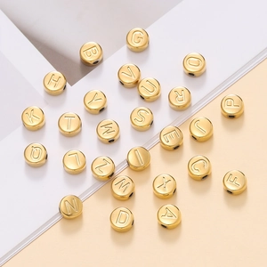 Détails macro des perles alphabétiques 7mm en acier doré pour création de bijoux