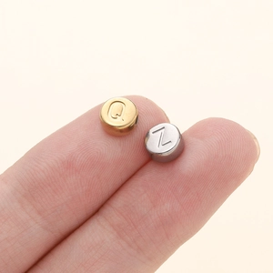 Gros plan sur des perles alphabet de 7mm en acier doré et argenté pour bijoux DIY