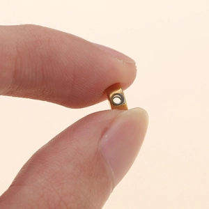 Vue macro d'une perle alphabet de 7mm en acier inoxydable doré et argenté pour la taille