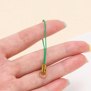 Detail of green woven cord with gold alloy ring for DIY handmade jewelry and phone charms