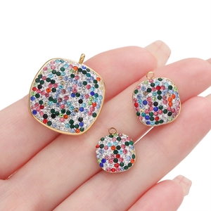 Macro view of three sizes of square stainless steel charms with colorful rhinestones