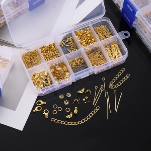 Detalle de kit de fornituras doradas para joyería DIY en caja organizadora de 10 rejillas
