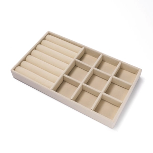 Detail van beige fluwelen sieradentray met ringgleuven en opbergvakken voor sieraden