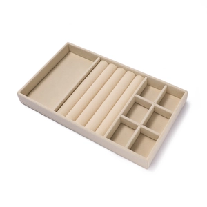 Detail van de beige fluwelen sieradendisplay met ringgleuven en handige opbergvakken in raster