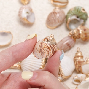 Makroaufnahme von natürlichen Muschelanhängern mit vergoldetem Rand für DIY-Schmuck