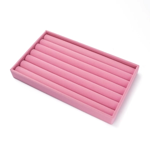 Detailopname van een roze fluwelen sieradendisplay met zeven gleuven voor ringen