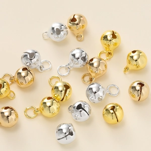 Macro-opname van goud- en zilkleurige metalen bellen met lussen voor DIY-sieraden