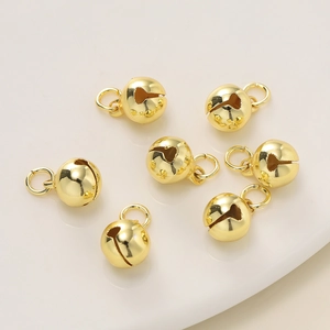 Macro-opname van zeven glanzende gouden bellen met gleuf voor DIY-sieraden en ambachten
