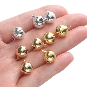Handheld weergave van diverse metalen belletjes in zilver, goud en brons afwerkingen