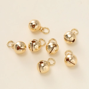 Macro-opname van gepolijste gouden mini metalen bellen met ringetjes voor DIY sieraden