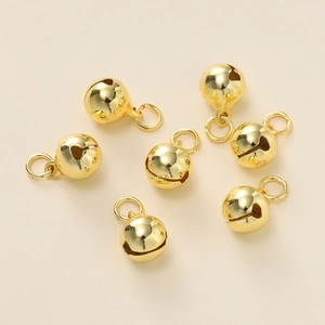 Detailopname van zes gepolijste gouden ijzeren belletjes met ringen voor DIY sieraden