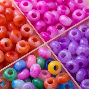 Macro-opname van kleurrijke gemarmerde acryl kralen in een plastic raster opbergdoos