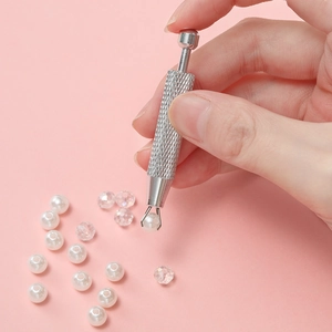 Outil de ramassage de bijoux à quatre griffes en aluminium saisissant une perle