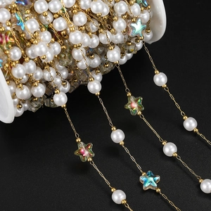 Macro shot of 18K gold star chain with pearls and colorful acrylic stars on spool