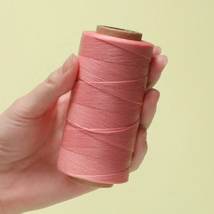 Dettaglio di filo cerato rosa da 0,8mm su rocchetto per cucito in pelle e DIY