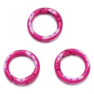 Detailopname van drie magenta geëmailleerde ronde veerringen met paarse stippen