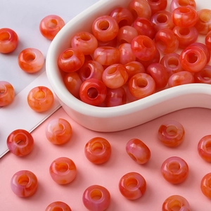 Macro-opname van ronde acrylkralen met oranje marmereffect voor DIY-sieraden maken