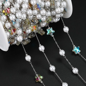 Macro detail of white pearls and iridescent star beads on a spool for DIY jewelry