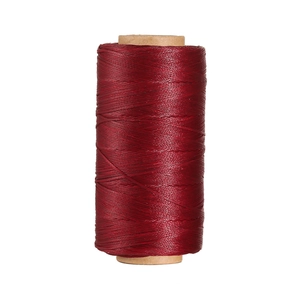 Dettaglio del filo di poliestere cerato bordeaux da 0,8 mm su rocchetto di carta