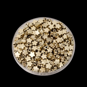 Vue détaillée de perles fleurs dorées pour création de bijoux DIY dans une boîte