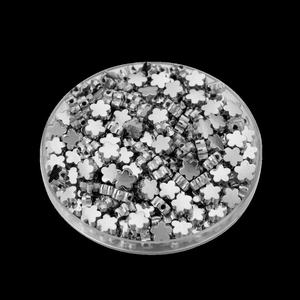 Detailopname van verzilverde bloemkralen in een ronde doos voor sieraden maken