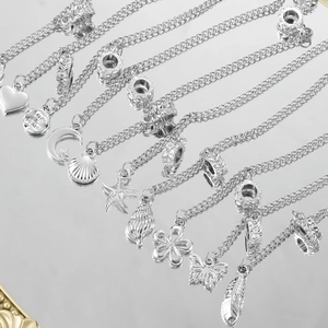 Dettaglio di ciondoli a catena di sicurezza in argento con stelle, lune e cuori