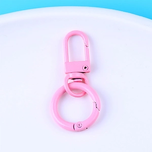 Close-up of pink painted zinc alloy lobster clasp with swivel ring on white surface