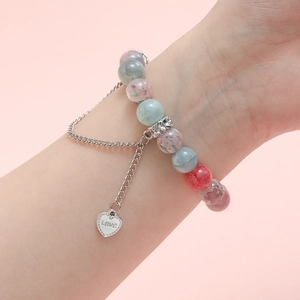 Bracciale romantico con perle colorate, ciondolo a cuore argentato e incisione Love
