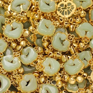 Macro shot of green jade-like Ruyi lock pendants with gold filigree and bells