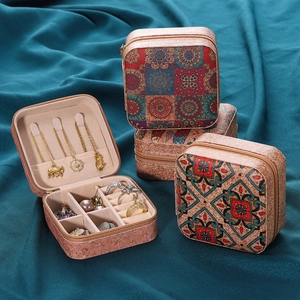 Detalle de joyero portátil con diseño mandala, ganchos de collar y ranuras de anillo