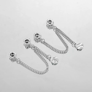 Vista macro di ciondoli argentati incisi Love & Peace per la creazione di bracciali fai-da-te