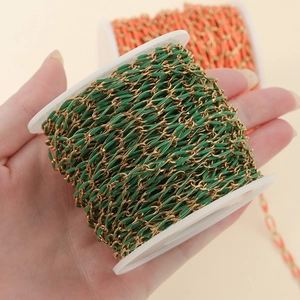 Colorful enamel oval link chain in gold stainless steel on a spool for DIY jewelry